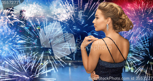 Image of woman with diamond earring over firework 