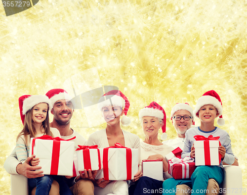 Image of happy family in santa helper hats with gift boxes