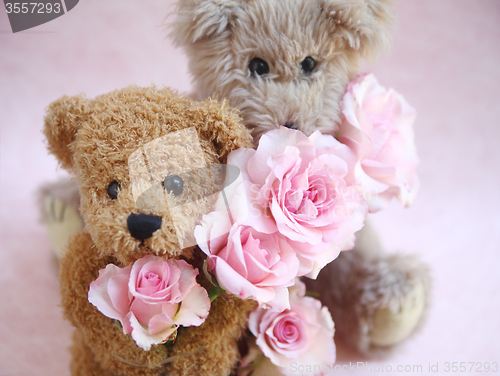 Image of two teddy bears holding roses