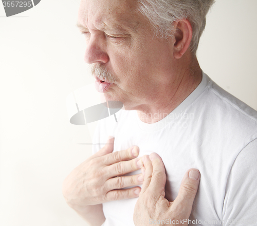 Image of Man exhales with hands on chest.