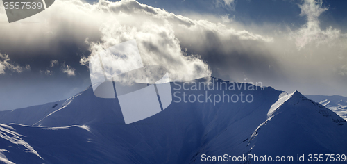 Image of Panoramic view of mountains in sunset with sunlit clouds