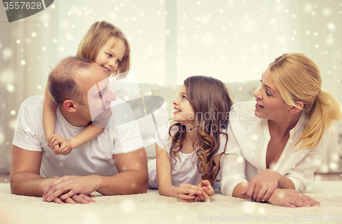 Image of smiling parents and two little girls at home