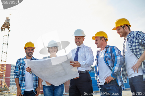 Image of group of builders and architects with blueprint