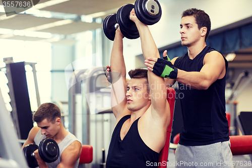 Image of group of men with dumbbells in gym