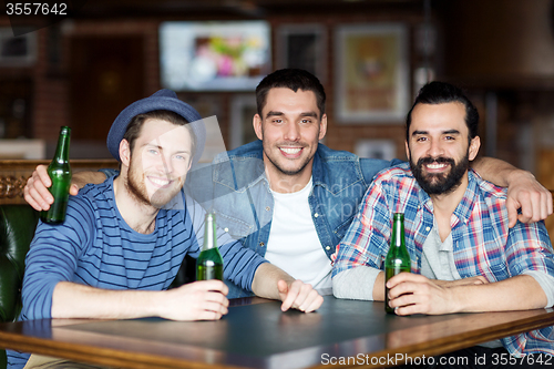 Image of happy male friends drinking beer at bar or pub