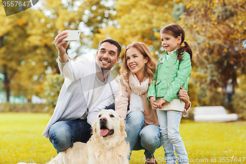 Image of happy family with dog taking selfie by smartphone