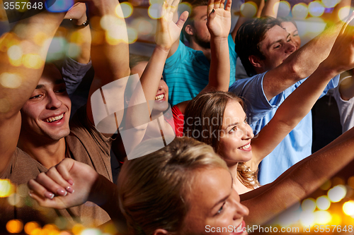 Image of group of smiling friends at concert in club