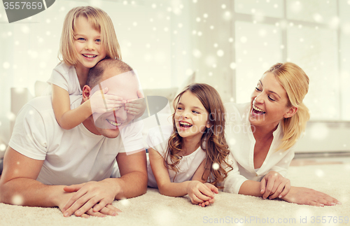 Image of smiling parents and two little girls at home