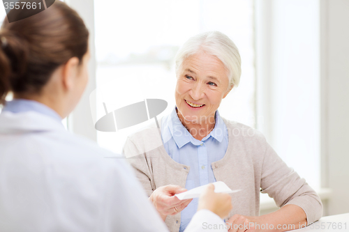 Image of doctor giving prescription to senior woman