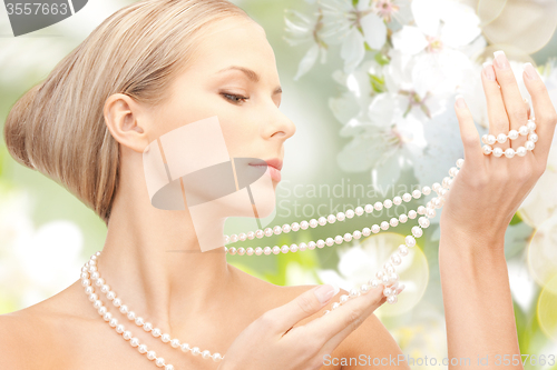 Image of woman with pearl necklace over cherry blossom