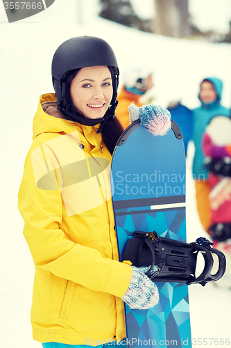 Image of happy friends in helmets with snowboards