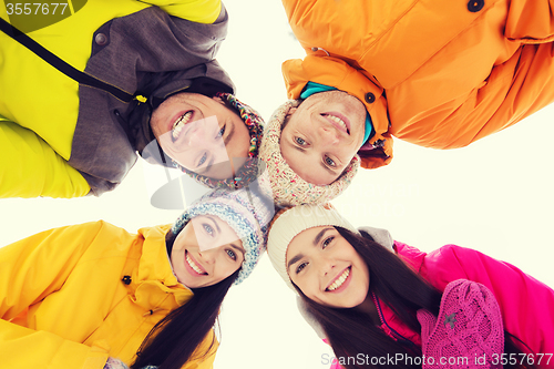 Image of happy friends in winter clothes outdoors
