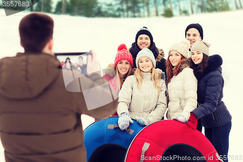 Image of group of smiling friends with snow tubes