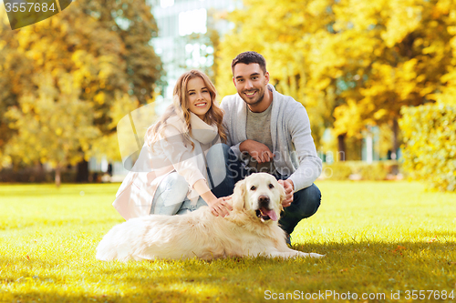 Image of happy couple with labrador dog autumn in park