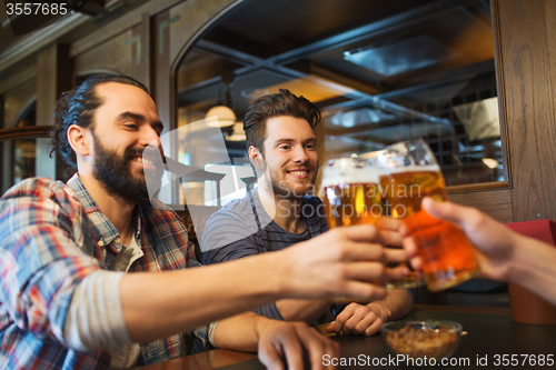 Image of happy male friends drinking beer at bar or pub