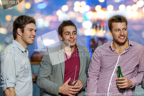 Image of group of male friends with beer in nightclub