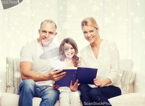 Image of happy family with book at home