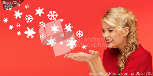 Image of woman sending snowflakes from palms of her hands