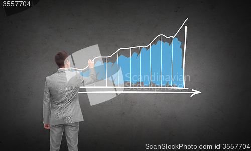 Image of businessman drawing diagram chart from back