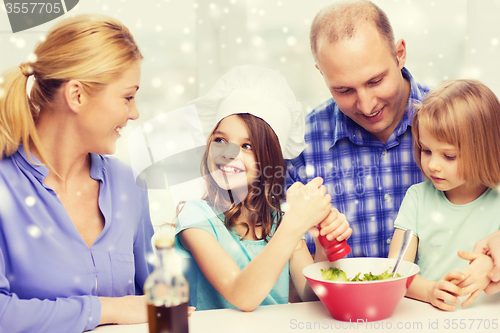 Image of happy family with two kids making salad at home