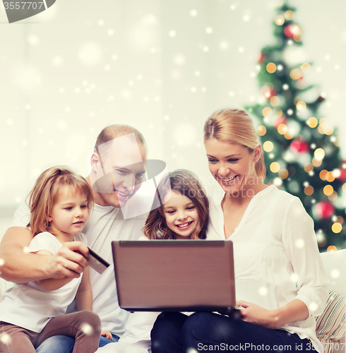 Image of happy family with laptop and credit card at home