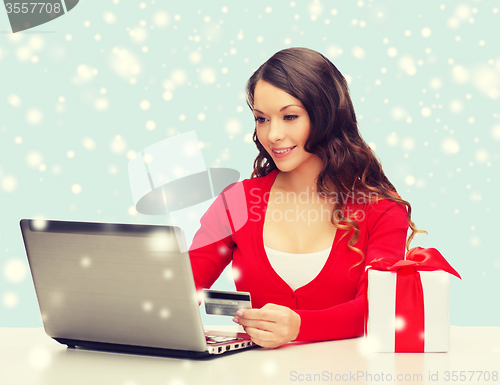 Image of woman with gift, laptop computer and credit card