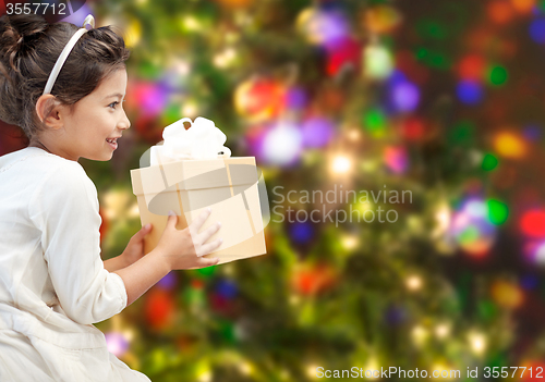 Image of happy little girl with present over lights