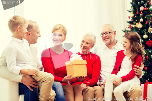 Image of smiling family with gifts at home