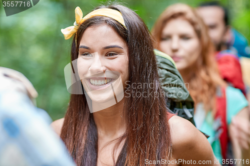 Image of group of smiling friends with backpacks hiking