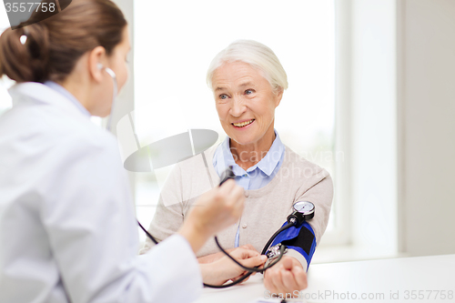 Image of doctor with tonometer and senior woman at hospital