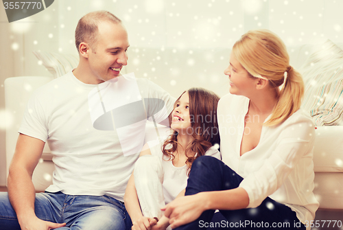 Image of smiling parents and little girl at home