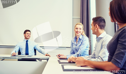 Image of group of smiling businesspeople meeting in office