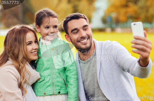 Image of happy family taking selfie by smartphone outdoors