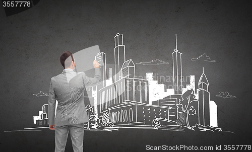 Image of businessman drawing city sketch from back