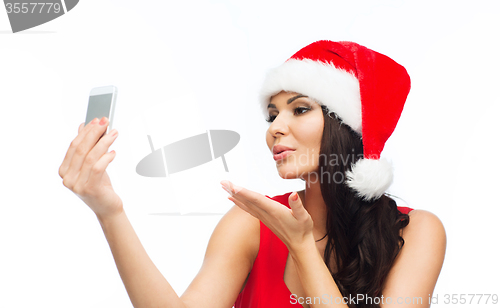 Image of woman in santa hat taking selfie by smartphone