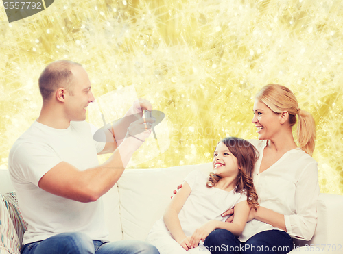 Image of happy family with camera at home