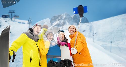 Image of happy friends with snowboards and smartphone