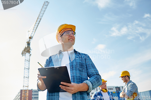 Image of builder in hardhat with clipboard at construction