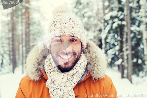 Image of smiling young man in snowy winter forest