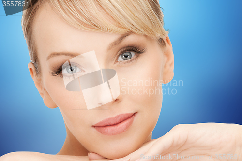 Image of beautiful young woman face over blue background