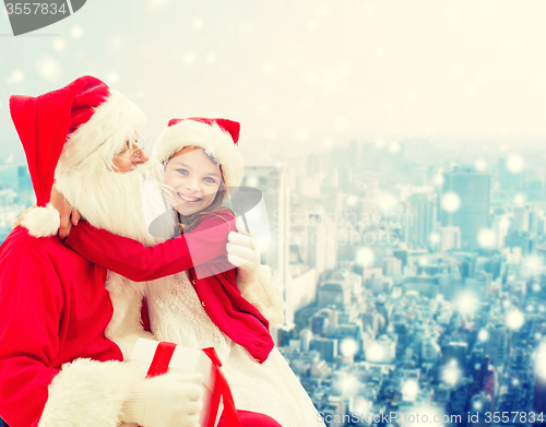 Image of smiling little girl with santa claus and gifts