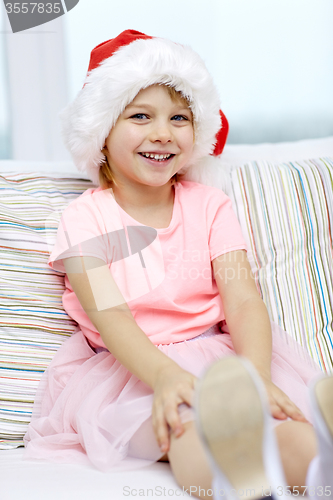 Image of smiling little girl in santa hat at home