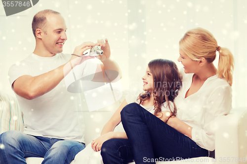 Image of happy family with camera taking picture at home