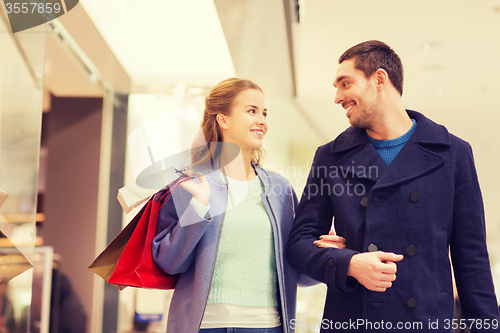 Image of happy young couple with shopping bags in mall