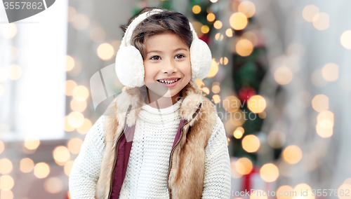 Image of happy little girl wearing earmuffs at christmas