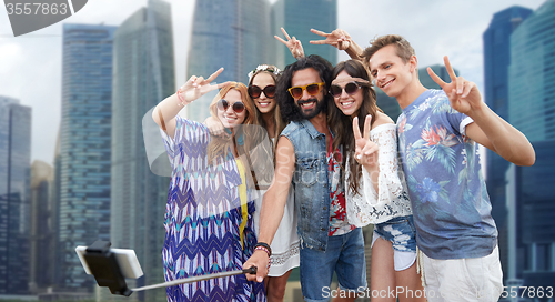 Image of hippie friends with smartphone selfie stick