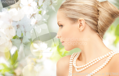 Image of woman with pearl necklace over cherry blossom