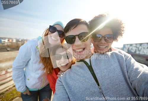 Image of group of happy friends taking selfie on street