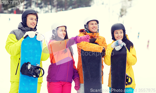 Image of happy friends in helmets with snowboards