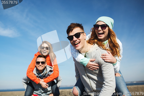 Image of happy friends in shades having fun outdoors